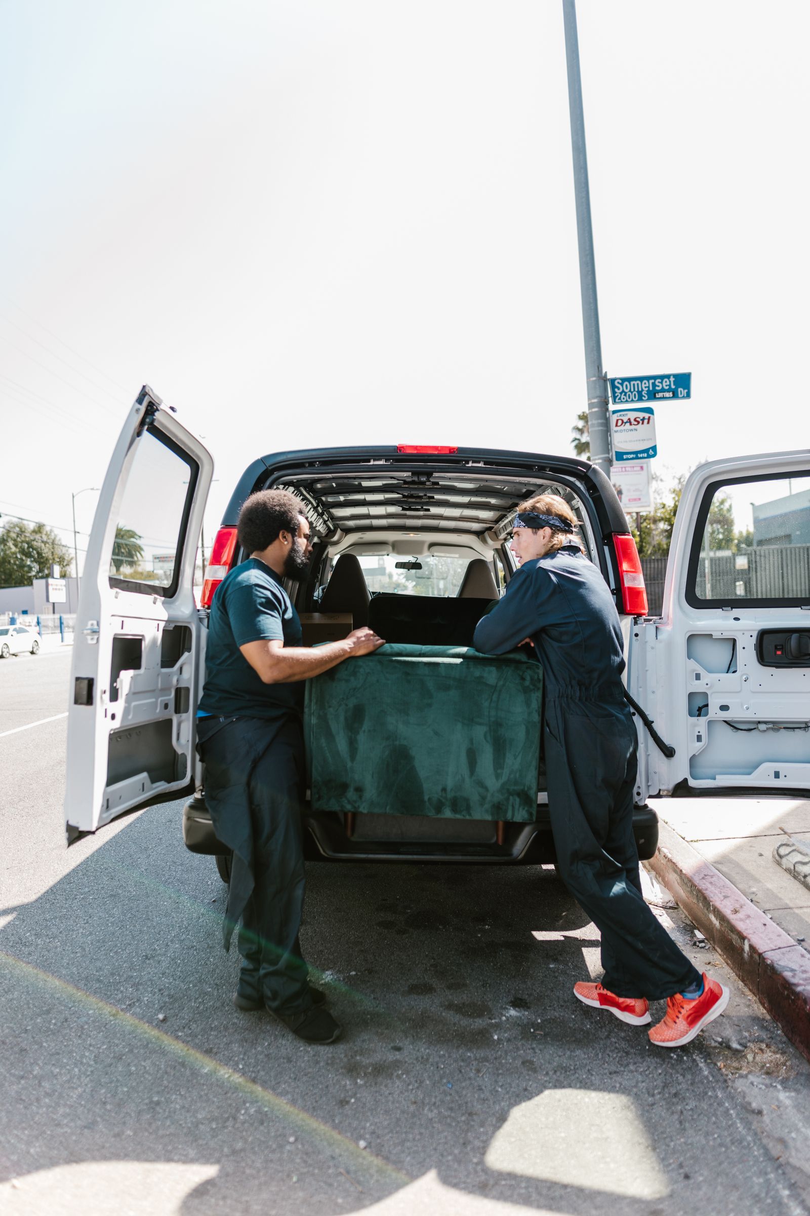 Two removals staff loading a van